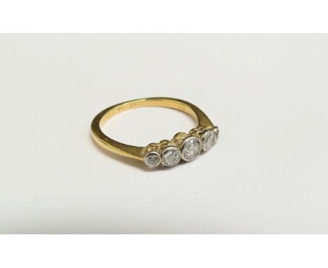 A gold ring set with five graduated diamonds in rubover setting, stamped 18ct. Size O, 2.6g 