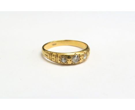 An 18ct gold three stone diamond gypsy ring. Size U, 4.1g 