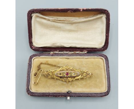 A 9ct gold brooch set with a central ruby flanked by diamonds within original box, 3.9gms 