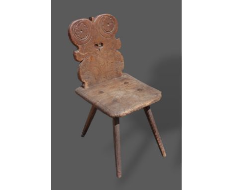 An early oak hall chair, the shaped pierced back inscribed 1632, with a panel seat and tapering legs 