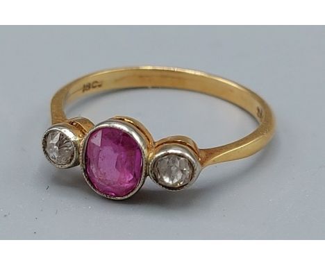 An 18ct gold ruby and diamond ring with a central ruby flanked by two diamonds, 2.2gms, ring size M 