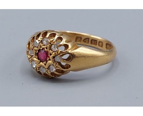 An 18ct gold ruby and diamond cluster ring set with a central ruby surrounded by diamonds, 4.4gms, ring size M 