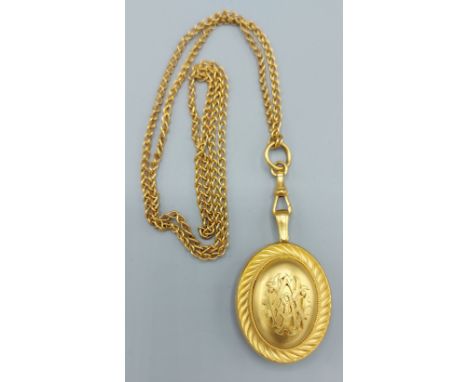 A Victorian oval locket together with a long guard chain 