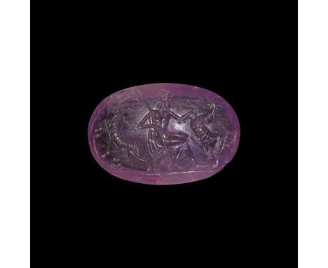 2nd-3rd century AD. A plano-convex amethyst plaque with intaglio scene of a seated huntsman with spear and helmet between rea