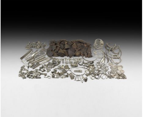 9th-11th century AD. A hoard of silver and ceramic items comprising: a chatelaine with pendants (ear-scoop, tweezers, hammer,