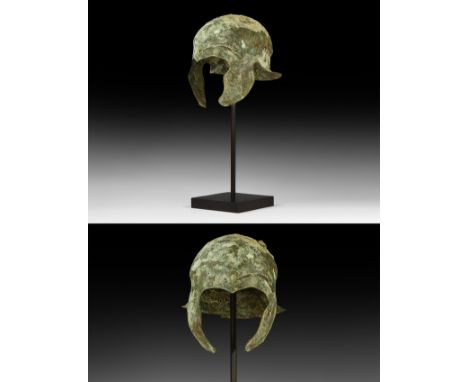 Early 4th century BC. A bronze helmet of Chalcidian type formed as a one-piece bronze bowl with carination to the crown and e