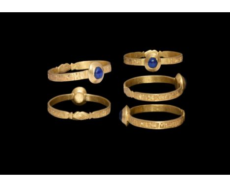 12th-13th century AD. A gold ring comprising a flat hoop with clasped-hands motif to the underside, panel of hatching with re