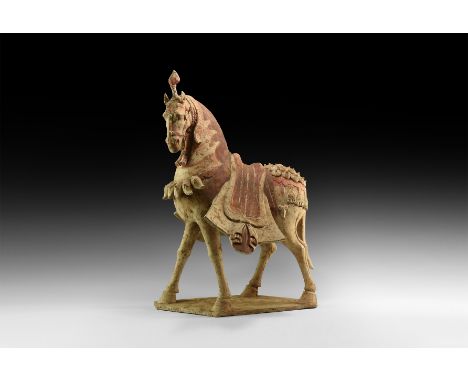 Warring States Period, 475-221 BC. A ceramic horse on an irregular base with arched neck and head turned, flared saddlecloth 