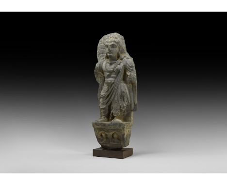 2nd-4th century AD. A carved schist statue fragment of Buddha standing a ledge with robe to the waist and sandals to the feet