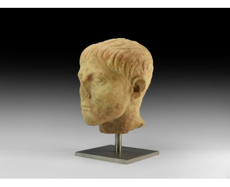 Early 1st century AD. An early Imperial marble bust of a youthful male, stern expression, slender face with short hair combed