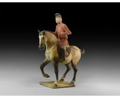 Tang Dynasty, 618-906 AD. A ceramic figurine depicting a horse and rider on a square base; the horse with arched neck and ope