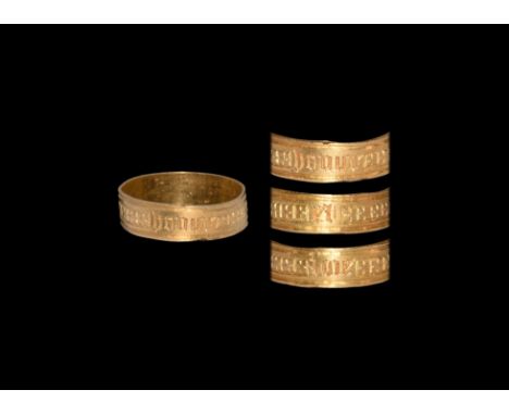 15th century AD. A gold ring comprising a flat band with raised rims, panels of quatrefoils between blackletter text 'honur e