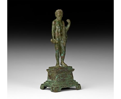 2nd-3rd century AD. A bronze statuette of Jupiter (Greek Zeus) standing nude with left leg slightly bent atop a pedestal, rig