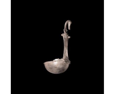 1st century BC. A silver simpulum ladle with shallow bowl and flared rim, volute scrolls to the rim beside the flat handle wi