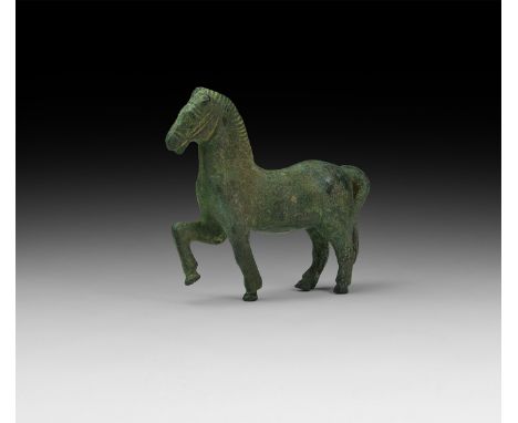 1st century BC-1st century AD. A bronze model of a horse advancing with one foreleg raised and bent, incised bridle detail to