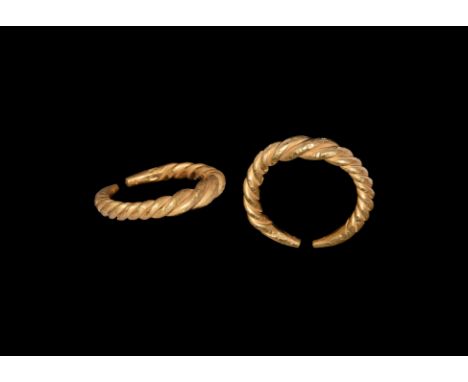2nd millennium BC. A gold penannular ring formed from two twisted rods with tapering ends.   11.85 grams, 28.98mm overall, 21