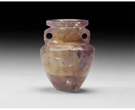 1st-2nd century AD. A carved amethyst vase with tapering body, chamfered shoulder, broad neck with lateral loops, flange rim.