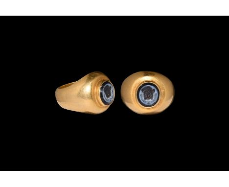 1st century BC-1st century AD. A nicolo intaglio with lion mask and wreath; set into a later gold ring comprising a tapering 