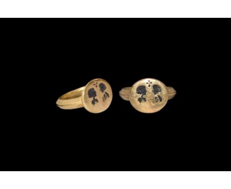 6th-7th century AD. A gold ring comprising a gusseted D-section hoop, discoid bezel with intaglio male and female opposed bus