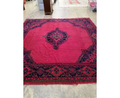 An Afghan red ground carpet, 330 x 314cm