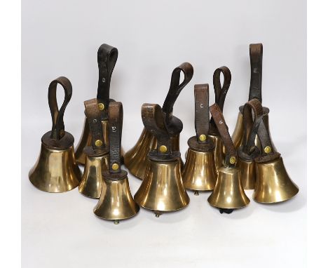 A set of thirty two musical handbells, full chromatic scale, circa 1900, largest 23cm, including leather strap