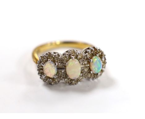 An 18ct, white opal and diamond chip set triple cluster dress ring, size K, gross weight 4.2 grams.