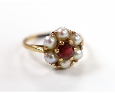 A 9ct gold, garnet and seed pearl cluster set flower head ring, size I, gross weight 2.4 grams.