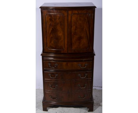 Reproduction mahogany small cocktail cabinet, bow-front form, the top with a moulded edge, two doors flanked by fluted quarte