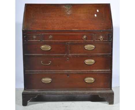 George III oak bureau, fall front enclosing an interior fitted with drawers, pigeon holes, secret compartment and a well abov