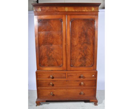 George IV mahogany linen press, moulded cornice inset with fleur-de-lys marquetry panels above a pair of panel doors enclosin