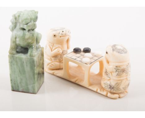 Japanese carved bone okimono, two toads playing draughts, 11cm; and two other carved bone okimonos; and a carved soapstone se