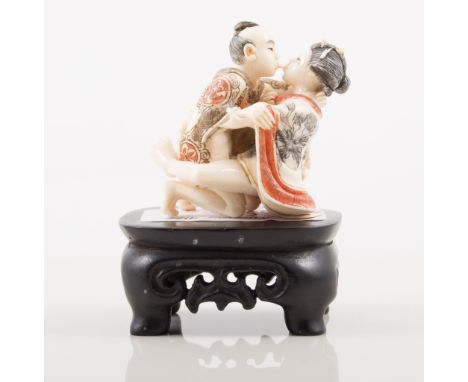 Japanese carved ivory erotic netsuke, two character mark, approximately 42mm, on a stand.