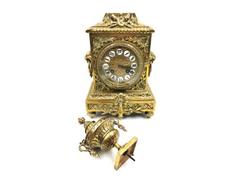 A French 19th century brass mantel clock with an embossed dial bearing Roman numerals and allover scrolling foliate design, w