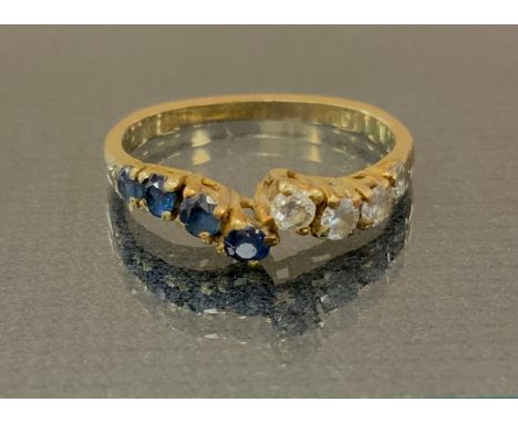 A diamond and sapphire dress ring, off set crest with slightly graduated four stone set shoulders, unmarked yellow metal shan