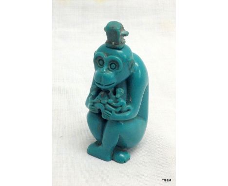 A figurine of a monkey in a turquoise forming a snuff box