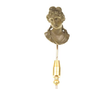 A late 19th century lava stick pinThe detailed carved lava depicting the bust of a classical female, to a precious yellow met