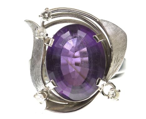 An amethyst and diamond dress ringCentering an oval shape amethyst, within a sculptural flared surround, with round brilliant