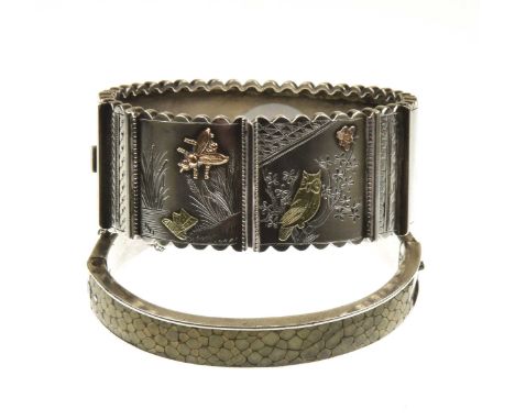 A Victorian aesthetic movement hinged bangleIn white metal, unmarked, with pink and yellow metal detail, applied and engraved