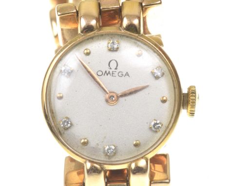 Omega: A ladies diamond set 18k gold manual wind bracelet watchThe circular silvered dial with applied diamond and gold hour 