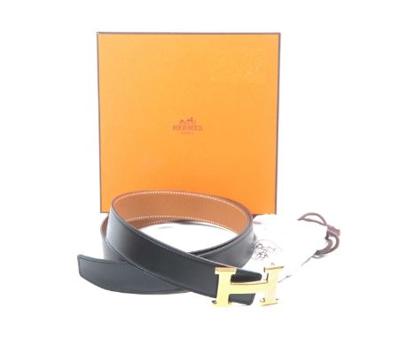 A Hermes leather beltThe soft black leather, with exposed stitching and tan leather interior, with embossed marks, and  strip