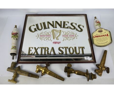 Two ceramic beer pump handles decorated with hunting scenes and a Guinness advertising mirror, approximately 43 cm x 53 cm. [