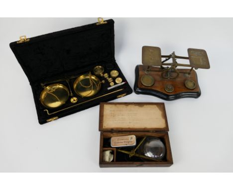 Three set of vintage scales comprising a set of postal scales (with weights), a boxed set of jewellers scales (with weights) 