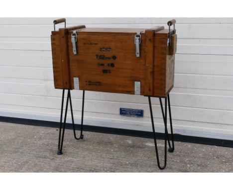 A raised chest formed from a 7.62 mm ammunition crate attached to iron supports, approximately 72 cm x 67 cm x 26 cm.