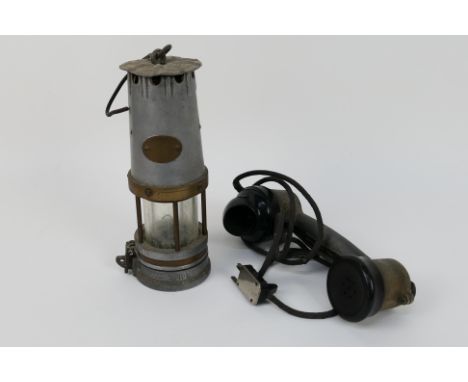 A vintage safety lamp and vintage telephone handset.