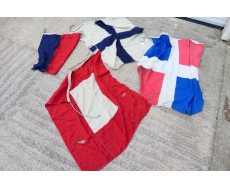 A collection of vintage maritime signal type flags, largest approximately 95 cm x 115 cm.