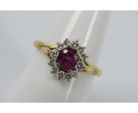 A yellow metal ruby and diamond cluster ring, stamped 0.750 for 18ct, size P, approximately 3.6 grams all in.
