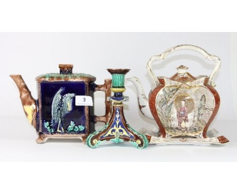 A 19th century majolica teapot, a Wedgwood majolica candlestick and a further oriental design teapot and stand