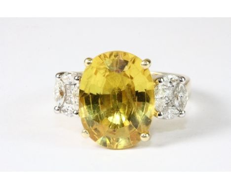 A superb 18ct yellow gold ring set with a large 8ct yellow sapphire and diamond shoulders (N.5). Est. £1600 - 2000.