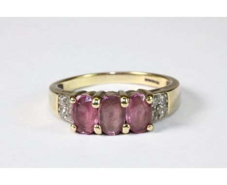 A 9ct yellow gold ring set with 3 pink sapphires and diamond shoulders (O)