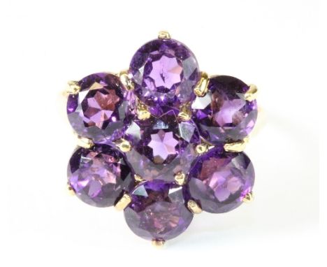 A very pretty 9ct yellow gold ring set with a cluster of large amethysts. Size R.